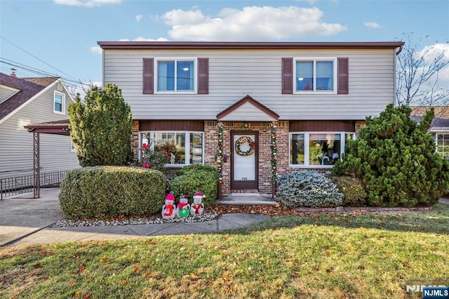 view of front facade with brick siding and a front lawn