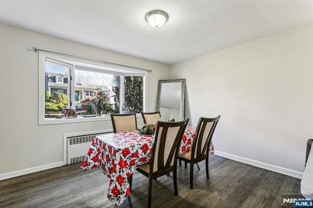 dining area with radiator heating unit, baseboards, and dark wood-style flooring