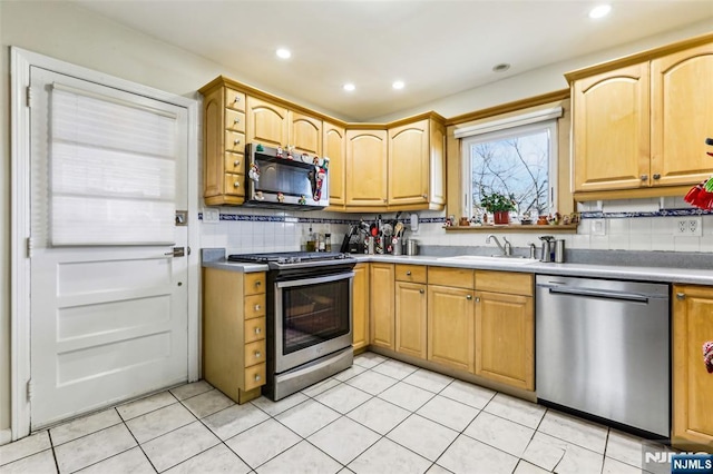 kitchen with light tile patterned floors, recessed lighting, a sink, appliances with stainless steel finishes, and tasteful backsplash