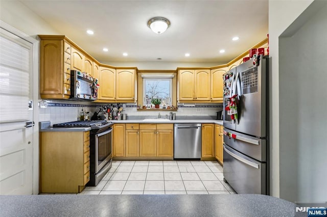 kitchen with light tile patterned floors, recessed lighting, a sink, appliances with stainless steel finishes, and decorative backsplash