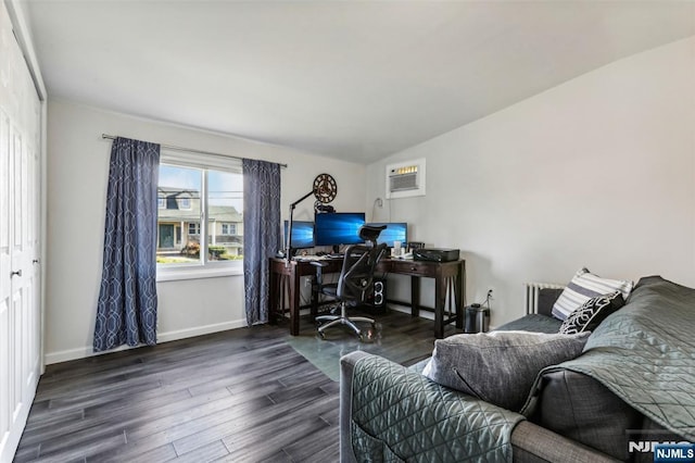 office area with an AC wall unit, baseboards, and wood finished floors