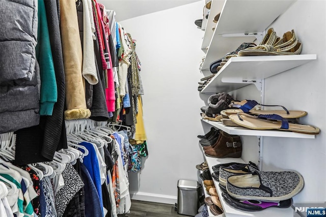 walk in closet with wood finished floors