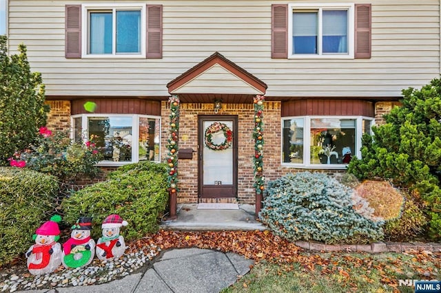 doorway to property with brick siding