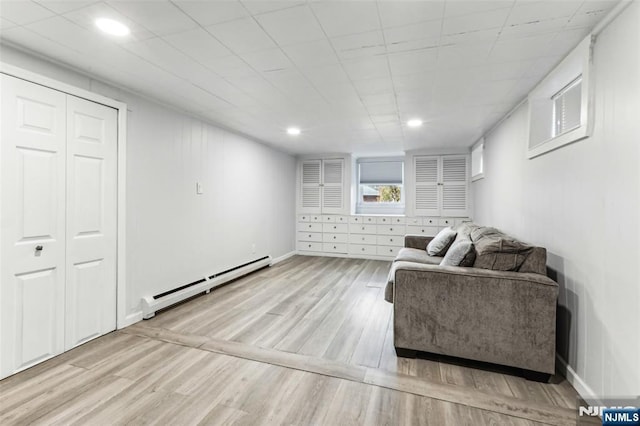 living room featuring light wood-type flooring, recessed lighting, a baseboard radiator, and baseboards