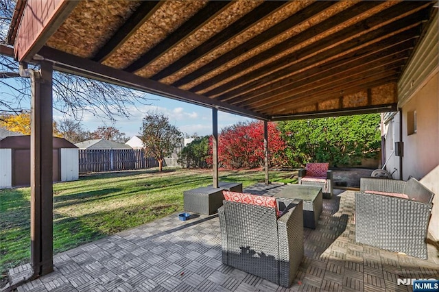 view of patio / terrace featuring an outbuilding, a fenced backyard, a storage shed, and an outdoor hangout area