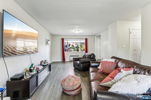 living area with radiator heating unit and wood finished floors