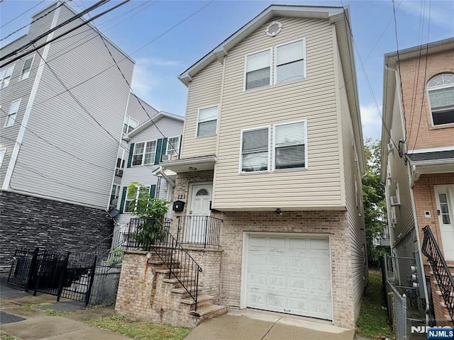 view of front of house featuring a garage, stairway, fence, and brick siding