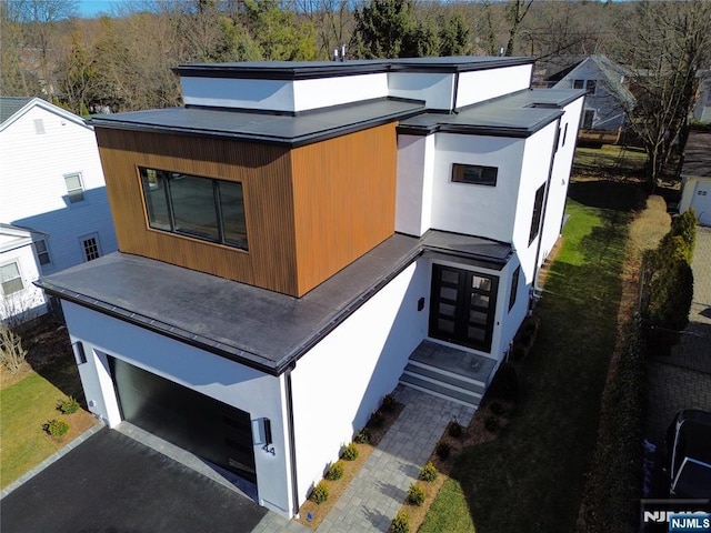 view of front of property featuring a garage, driveway, and stucco siding