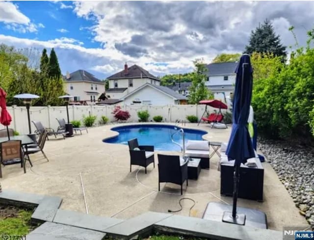 view of pool featuring a patio area and a fenced backyard