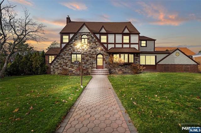 tudor-style house with a chimney and a front lawn