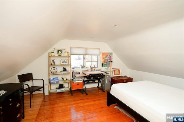 bedroom with lofted ceiling and light wood finished floors