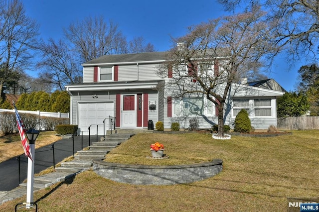 traditional home featuring a garage, fence, and a front lawn