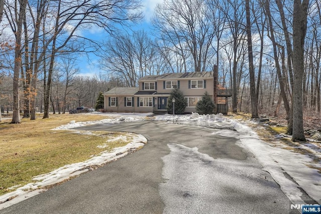 view of front of property with driveway and a chimney