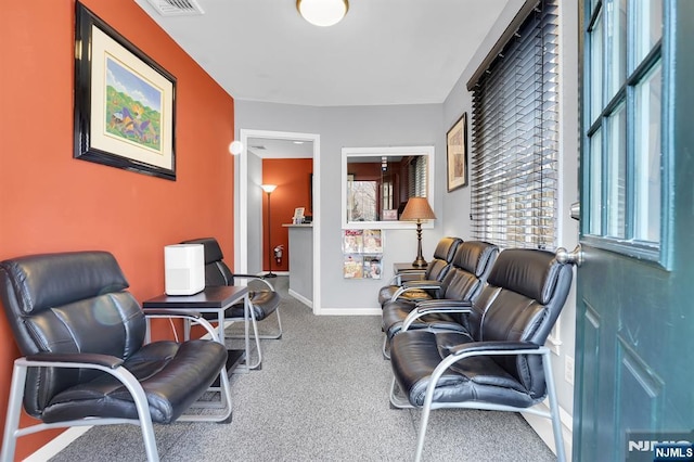 sitting room with carpet flooring, visible vents, and baseboards