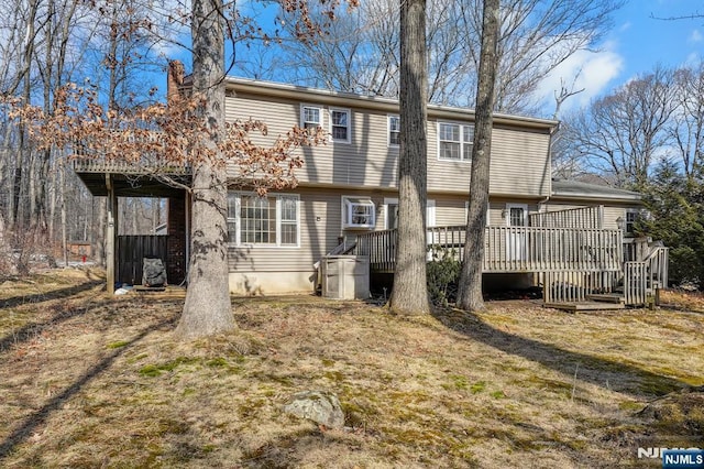 rear view of property with a yard and a deck