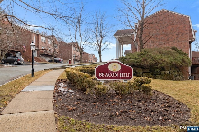 community / neighborhood sign featuring a residential view and a lawn