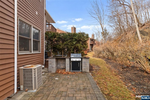 view of patio featuring cooling unit, a grill, and an outdoor kitchen