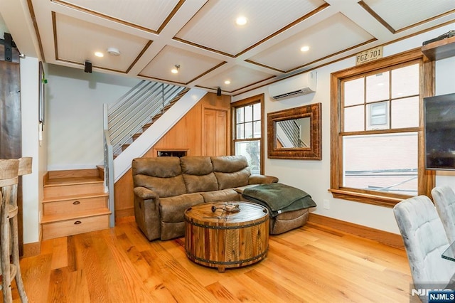 living room with a barn door, coffered ceiling, wood finished floors, stairs, and a wall mounted AC