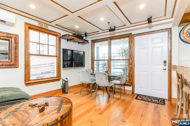 interior space with wood finished floors, a wall unit AC, and coffered ceiling