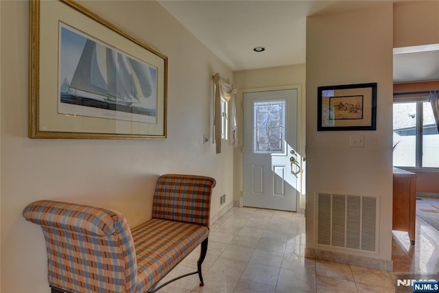 doorway featuring light tile patterned floors, visible vents, and baseboards