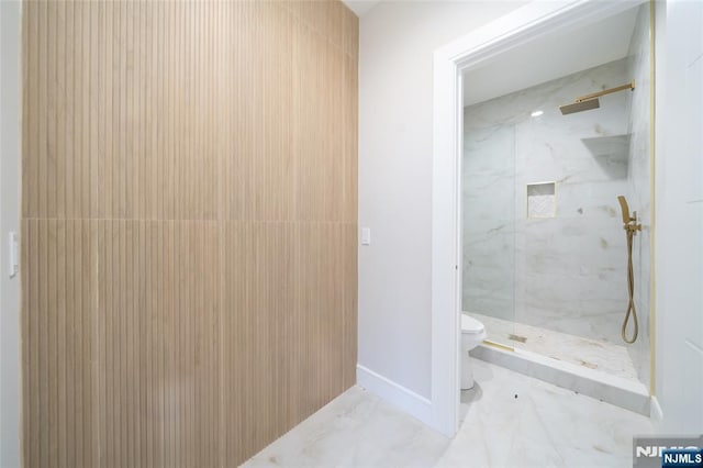 bathroom with a marble finish shower, baseboards, marble finish floor, and toilet