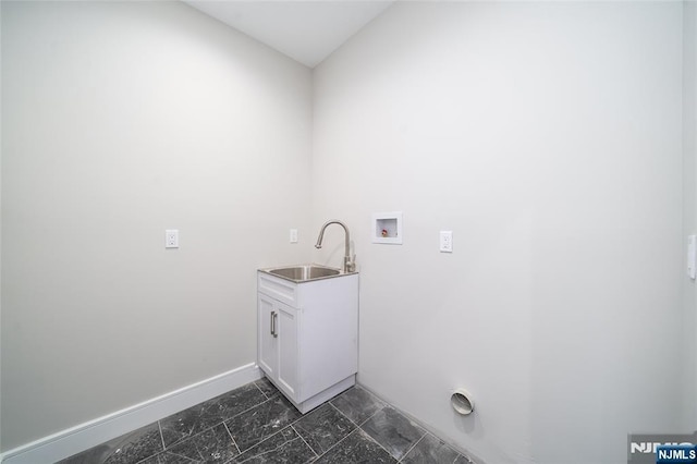 washroom with washer hookup, a sink, cabinet space, and baseboards