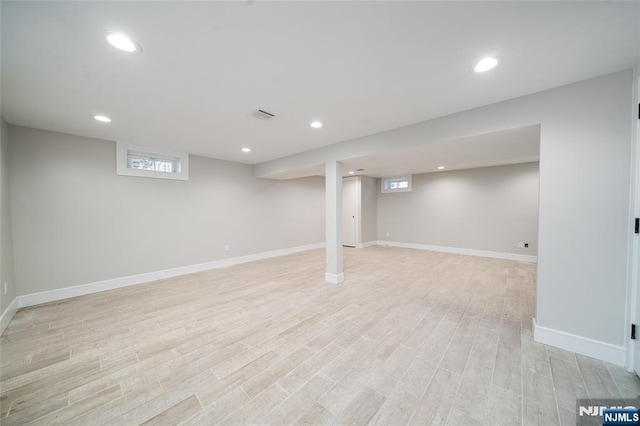 basement with light wood-style flooring, visible vents, and recessed lighting