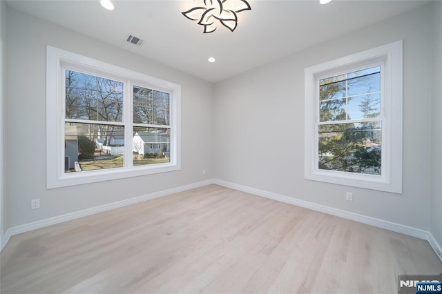 spare room with light wood-style flooring, recessed lighting, visible vents, and baseboards