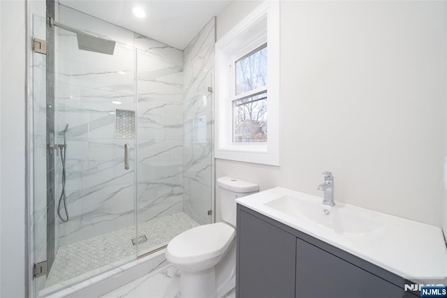 full bath with marble finish floor, vanity, a marble finish shower, and toilet