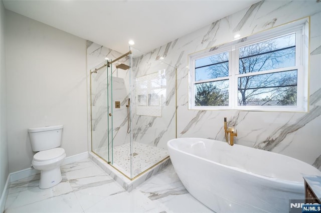 bathroom with toilet, baseboards, a freestanding bath, marble finish floor, and a marble finish shower