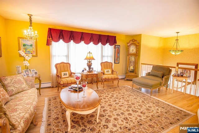 living room with light wood-style floors, baseboards, baseboard heating, and a chandelier