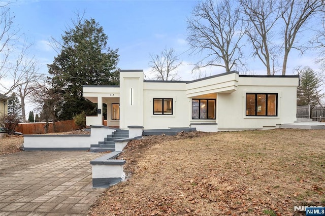 view of front of home with fence and stucco siding