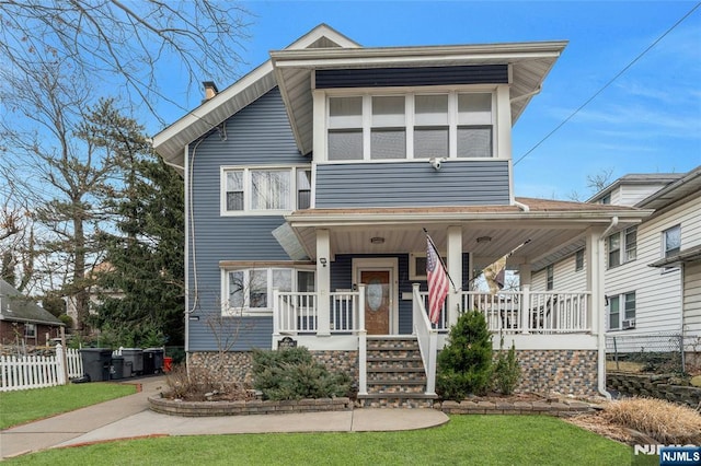 view of front facade featuring a porch and fence