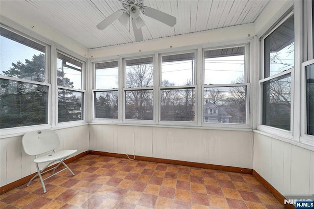 unfurnished sunroom with a ceiling fan and a healthy amount of sunlight