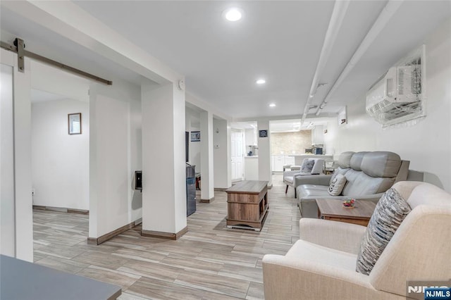 living room featuring baseboards, a barn door, and recessed lighting