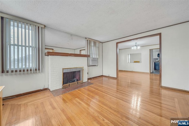 unfurnished living room featuring hardwood / wood-style flooring, a fireplace, and a textured ceiling