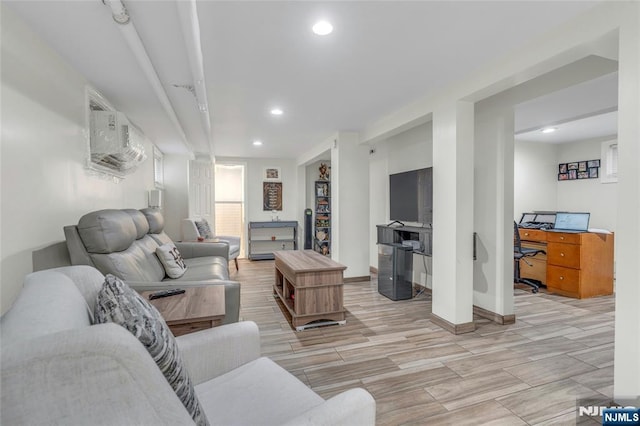 living room with recessed lighting, a wall unit AC, baseboards, and wood finish floors