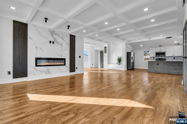 unfurnished living room featuring a fireplace, coffered ceiling, wood finished floors, and recessed lighting