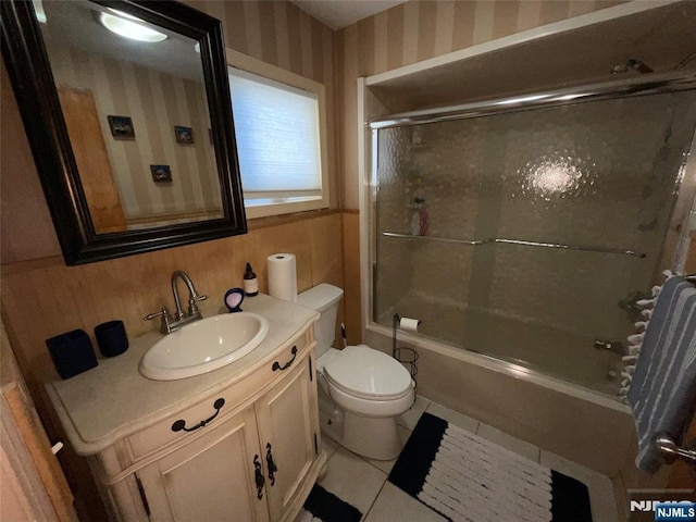 full bathroom with toilet, vanity, combined bath / shower with glass door, tile patterned floors, and wallpapered walls