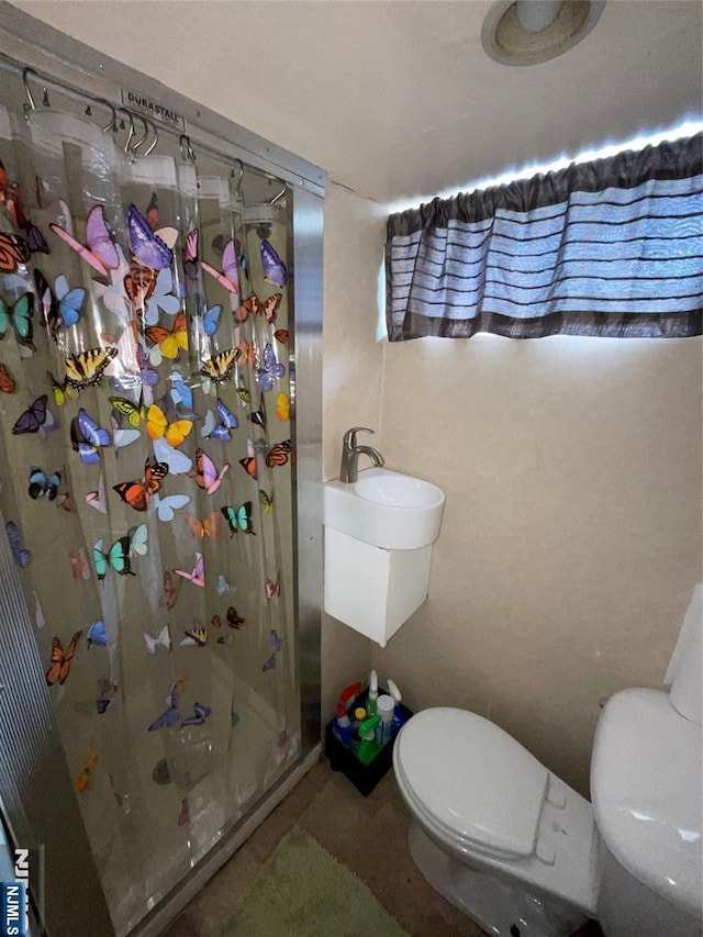 bathroom featuring toilet and walk in shower