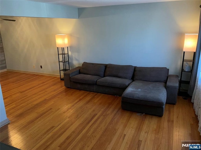 living area featuring baseboards and wood finished floors