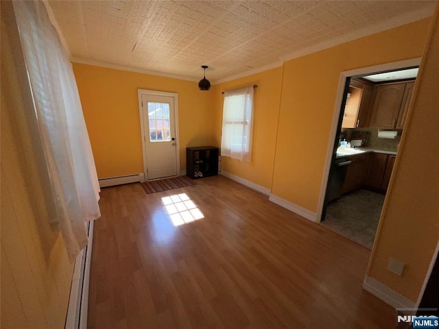 empty room with ornamental molding, a baseboard radiator, wood finished floors, and baseboards