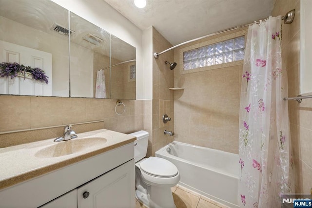 full bathroom with vanity, visible vents, tile walls, decorative backsplash, and shower / bathtub combination with curtain