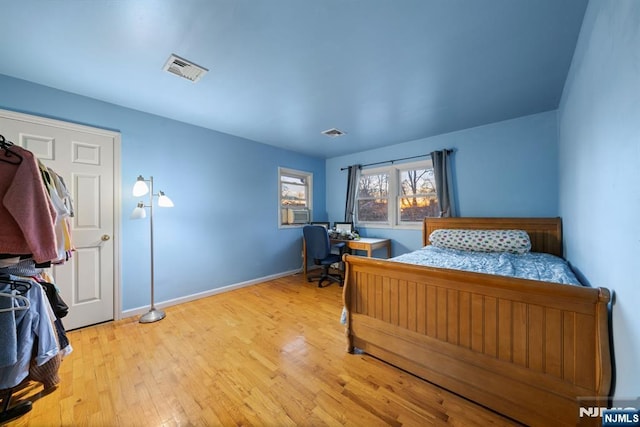 bedroom featuring visible vents, light wood-style flooring, and baseboards