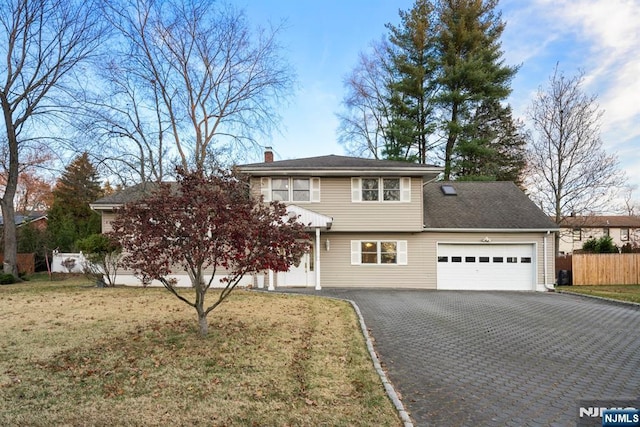 traditional home featuring driveway, a front lawn, a chimney, and fence