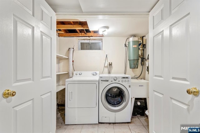 washroom featuring a sink, laundry area, light tile patterned flooring, and washing machine and clothes dryer