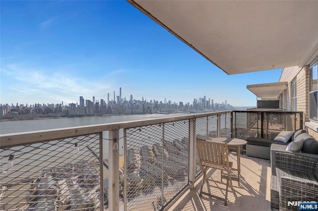 balcony featuring a city view and a water view