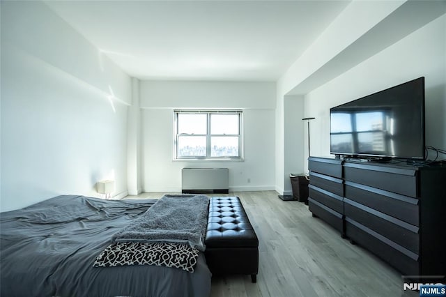 bedroom featuring baseboards and light wood finished floors