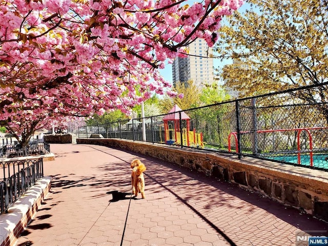 view of home's community with fence and playground community