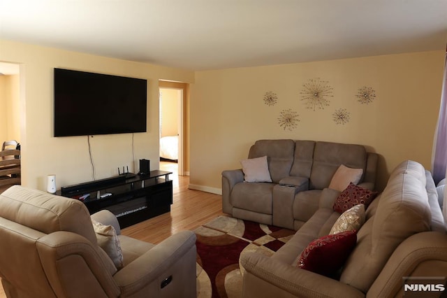 living area featuring light wood-style floors and baseboards